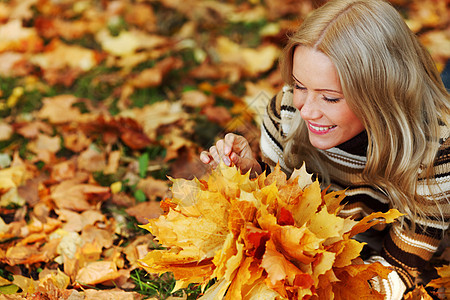 秋叶中的妇女脚尖头发季节乐趣幸福眼睛成人感恩公园微笑女性图片
