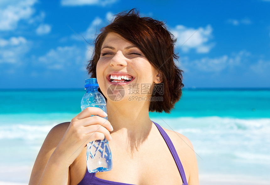 以水瓶为幸福的女子中年女性活力金发享受海滩天空快乐海洋瓶子图片