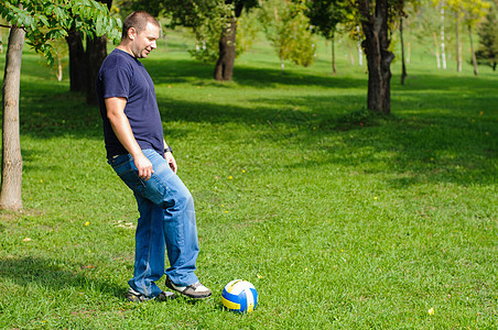 青年男子足球运动员牛仔裤运动公园娱乐游戏闲暇假期男性绿色男人图片