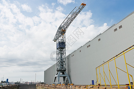 Crane靠近船坞一个覆盖的干燥码头技术机器起重机修理采摘货运工作蓝色造船建筑图片
