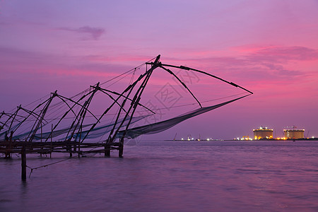 日落时中国鱼网 印度喀拉拉邦科奇渔夫支撑钓鱼渔网太阳高知日落绳索地平线图片