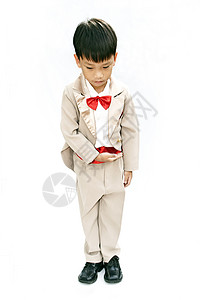 小男孩有棕色晚礼服和红领领结微笑孩子青年快乐白色燕尾服套装冒充剧院童年背景图片
