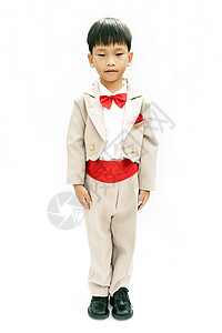 小男孩有棕色晚礼服和红领领结孩子微笑燕尾服套装快乐童年白色男生冒充剧院背景图片