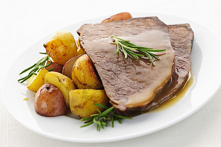 烤牛肉和土豆牛肉蔬菜红色肉汁晚餐服务褐色腰部雕刻棕色图片
