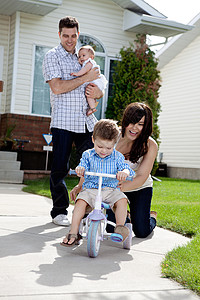 快乐的母亲教儿子骑三轮车图片
