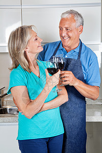 年老夫妇烤面包葡萄酒厨房饮料退休已婚围裙烹饪女士丈夫老年女性图片
