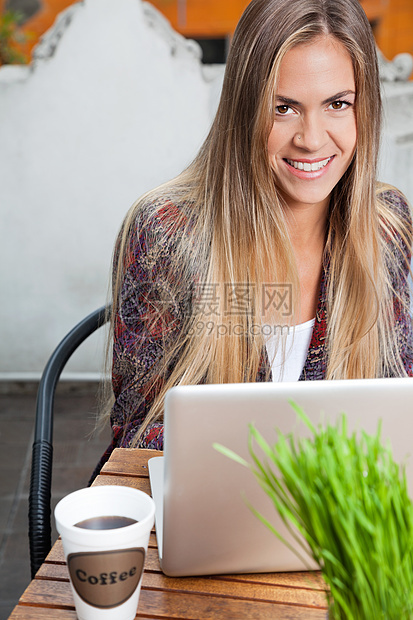 在咖啡厅用笔记本电脑的美丽女子图片