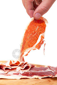 薄薄的西班牙Jamon 用一只手烹饪美食猪肉白色小吃塔帕切割木板营养午餐图片