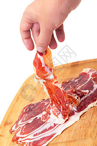 薄薄的西班牙Jamon 用一只手午餐猪肉木板小吃塔帕白色切割美食营养食物图片