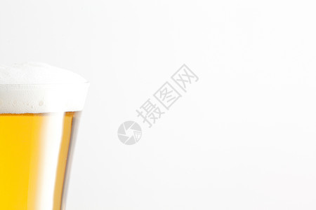 白色背景的啤酒和泡沫玻璃杯;图片