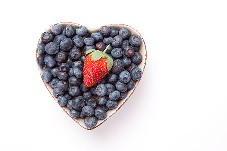 蓝莓和一片草莓 在心形的碗里图片