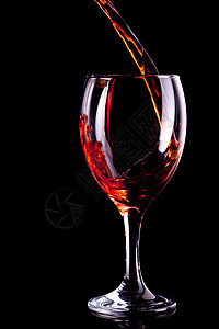 酒倒在玻璃杯中红色玻璃高脚杯饮料微光酒精反射背景图片