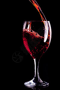 红酒倒入玻璃杯中酒精高脚杯红色饮料玻璃反射微光背景图片