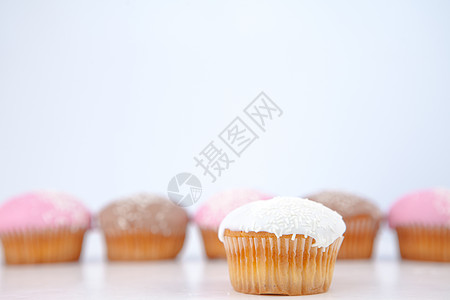 粉色蛋糕松饼和冰糖放在松饼前的松饼前面背景