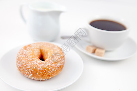 原味甜甜圈甜甜圈加糖霜和一杯咖啡放在白盘子上背景