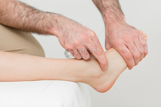 一名理疗师的手对病人的脚进行按摩图片