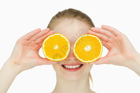紧贴着一个微笑的女人 把橘子放在她的眼睛上图片