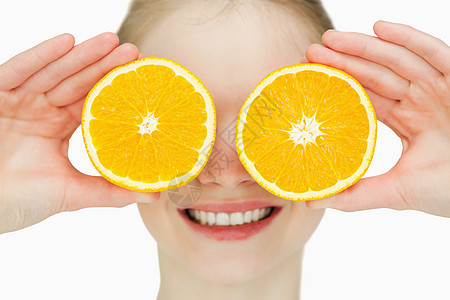 近距离接近一个快乐的女人 把橙子放在她的眼睛上图片