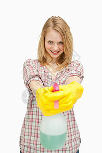 手持喷雾瓶的笑女人微笑塑胶享受女士家庭黄色手套卫生洗涤剂家务图片