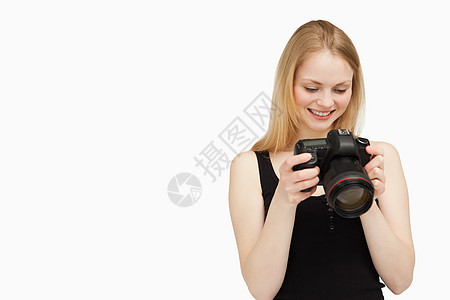 开心的女士看着她的相机图片