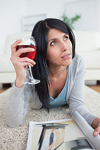 女人拿着红酒和一本杂志 一边想着自己高清图片