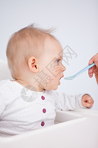 美丽的小女孩被喂一勺汤匙图片
