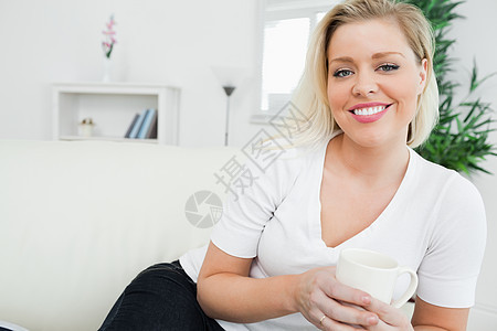 喝咖啡的女人牛仔裤清凉头发饮料金发浅色休息室微笑沙发巧克力图片