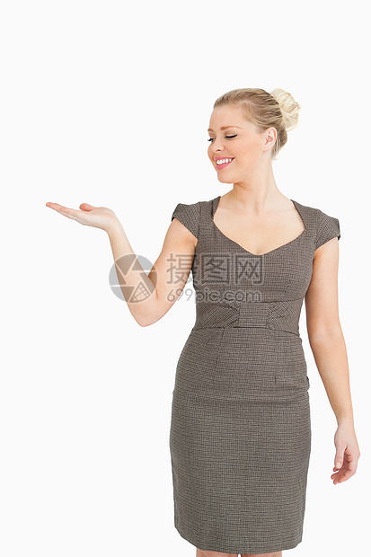 女人笑着用她的手展示一些东西快乐人士女性金发女郎管理人员套装商务棕色白领微笑图片