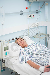 睡在闭着眼睛躺在医疗床上的女病人图片