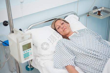 女病人在看照相机时躺在床上图片