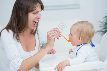母亲在张开嘴时喂养婴儿图片