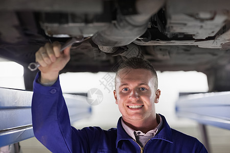 用打手修理汽车时微笑的机械工图片