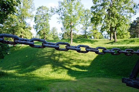 生锈钢链和绿丘图片