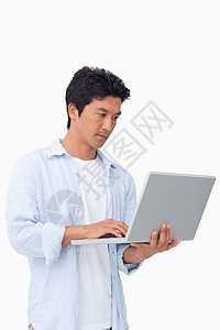 年轻男性在笔记本电脑上工作图片
