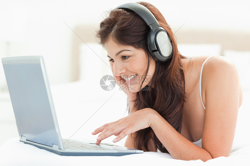 微笑的女人利用鼠标板在笔记本电脑上滚动图片