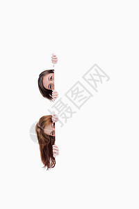 两个少女把头从一张空白海报上挖出来图片