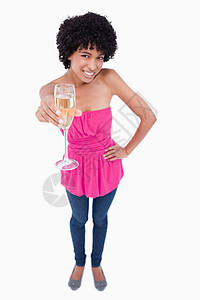 年轻女子拿着一杯白葡萄酒时笑着微笑图片