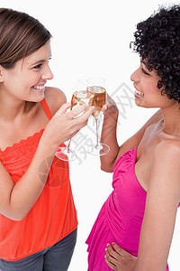 两名女青年面对面地碰着杯子 对面站立在一起背景图片