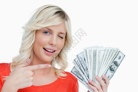 女人眨眼时用美元币指着她的手指图片