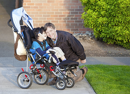 坐在轮椅上的残疾男孩及其照料者图片