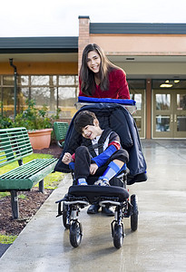 少女推拉坐在轮椅上的小残疾男孩图片