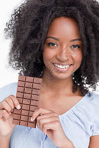 带着巧克力棒的卷发 微笑着年轻女人图片