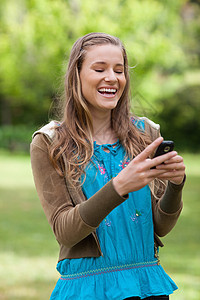 青少年女孩在听手机短信时笑着笑着图片