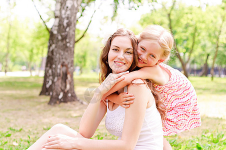 母亲和女儿一起坐在草地上场地女士妈妈花园放松成人乐趣圆圈女性喜悦图片