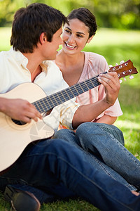 女人在朋友弹吉他时微笑图片