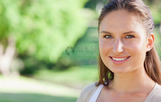 微笑的女人在公园里度过自己的一天森林女性阳光自由闲暇绿色女士享受树叶图片