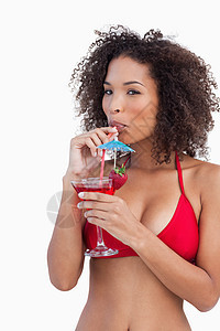 年轻女人一边喝鸡尾酒 一边看镜头图片