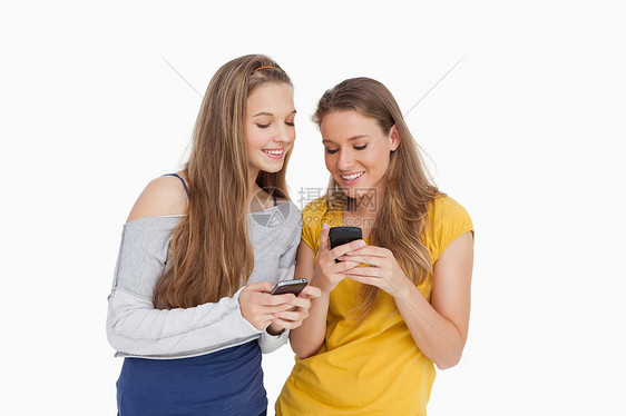 两个年轻女性在看手机时微笑着笑容图片