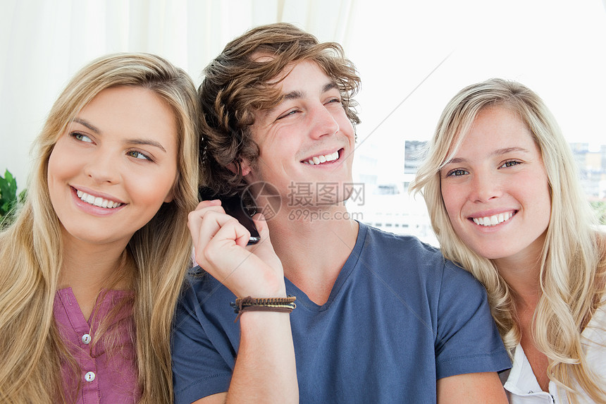 三个朋友在听一个电话谈话的听力朋友们成年人女性金发长椅外表快乐金发女郎年轻人图片