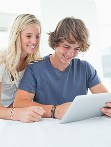 一对夫妇在使用平板电脑时微笑图片